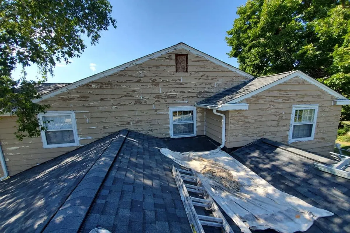 Home exterior with worn tan siding before painting