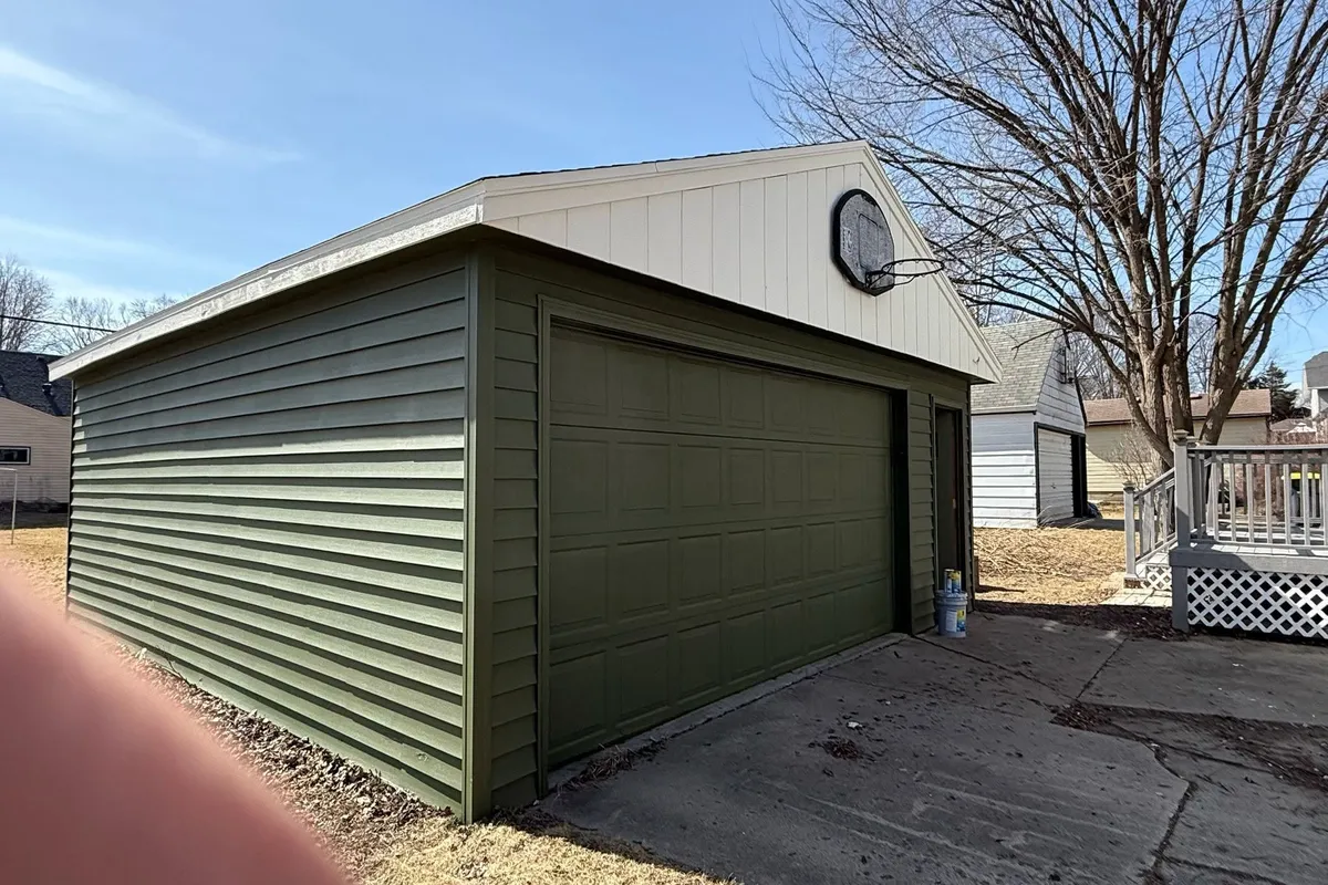 Garage door and siding painted with dark green Sherwin Williams paint